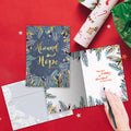 Load image into Gallery viewer, The inside of Tree-Free’s Abound In Hope Holiday Card card, with the cover and envelope in the background.
